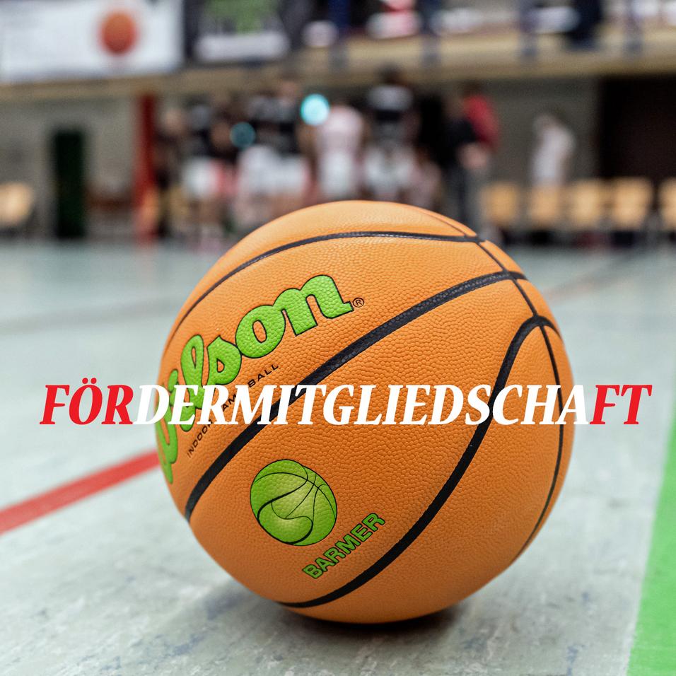 Nahaufnahme eines Basketballs mit dem Schriftzug „Fördermitgliedschaft“ in roter Schrift auf dem Spielfeld.