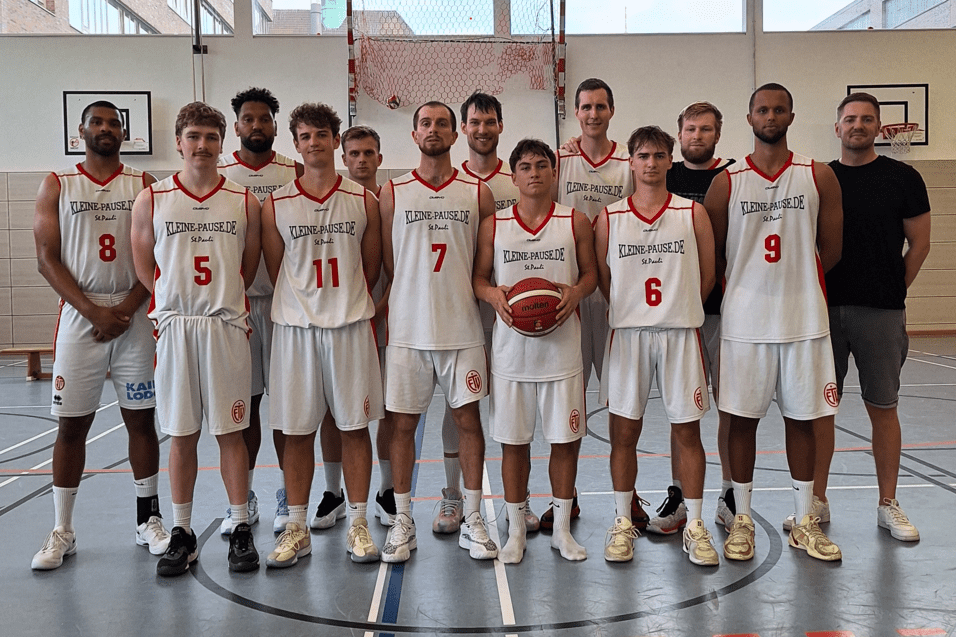 Mannschaftsfoto einer Basketballmannschaft mit 12 Spielern in weißen Trikots auf einem Basketballfeld.