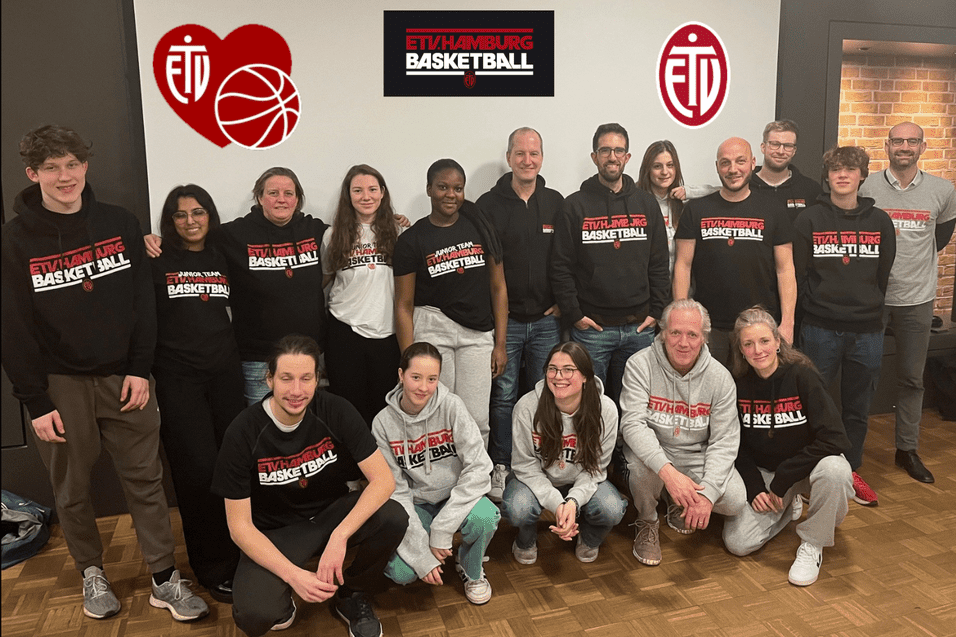 Gruppenfoto des Trainer*innenteams der ETV Jugend Basketball, stehend und sitzend vor einem Banner mit dem Logo.