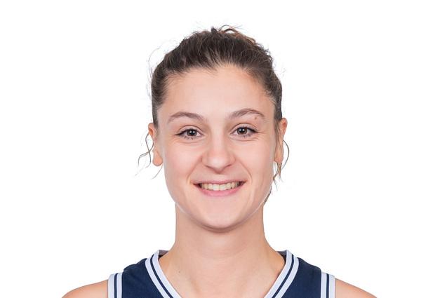 Portrait einer Basketballspielerin in einem dunkelblauen Trikot mit der Nummer 14 und Sponsorenlogos.