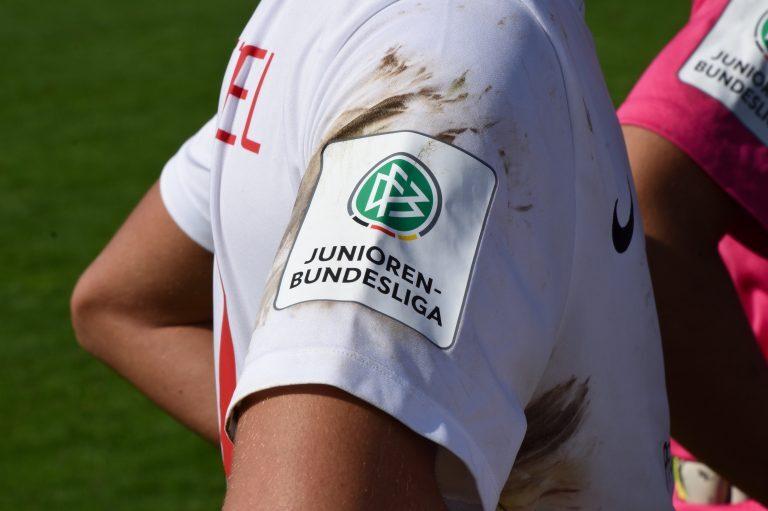 Nahaufnahme des Trikots eines Spielers mit dem Logo der Junioren-Bundesliga auf dem verschmutzten Ärmel.