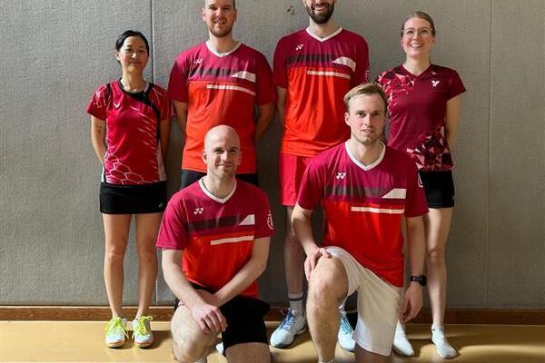 Sechsköpfiges Tischtennisteam in Sportkleidung, posierend auf einem hallenartigen Untergrund.