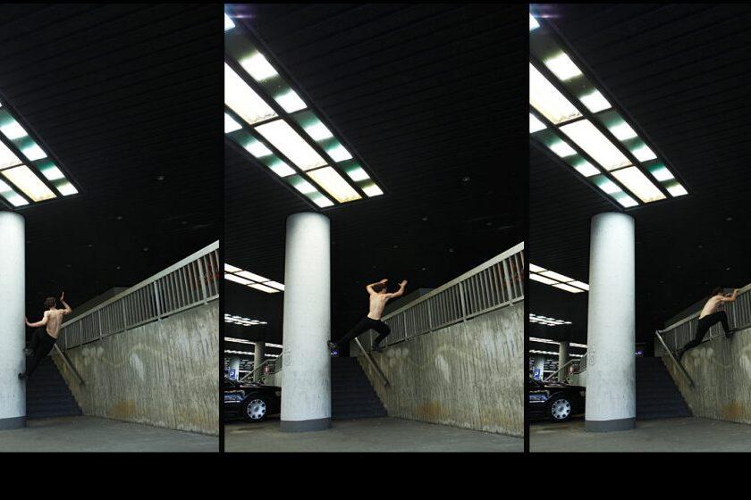 Skater springt über eine Treppe und landet auf einem Geländer in einer urbanen Umgebung.